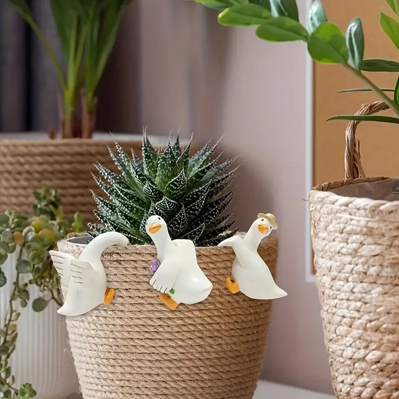 Canard décoratif en résine accroché à un cache-pot sur une terrasse