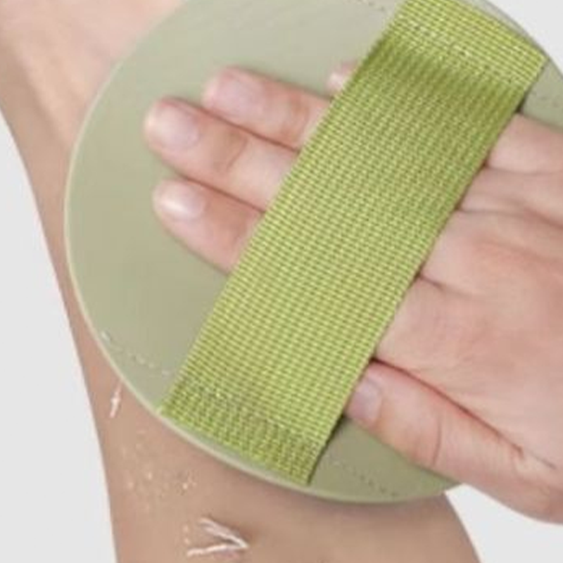 Vue rapprochée du gant exfoliant Derméa mouillé en utilisation