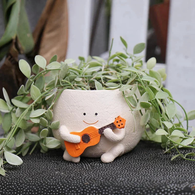 Pot de fleurs smiley en résine Florizia avec plante verte sur fond clair