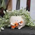 Pot de fleurs smiley en résine Florizia avec plante verte sur fond clair