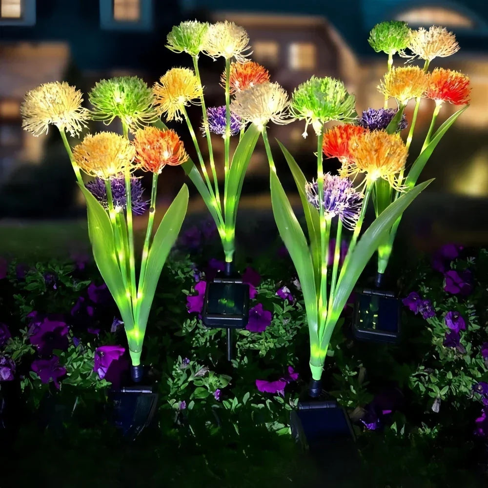 Borne solaire de jardin Soléria au design pissenlit plantée dans une pelouse