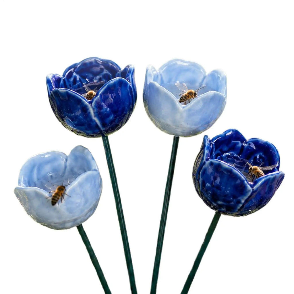 Abreuvoir à nectar posé dans un massif fleuri pour attirer les pollinisateurs