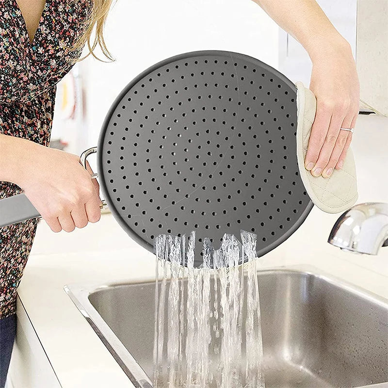 Pare-éclaboussures Cuizya posé sur une poêle pendant la cuisson